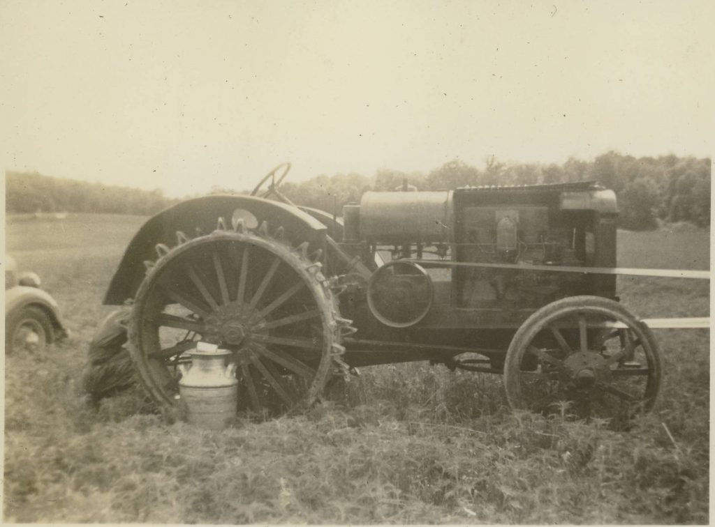 Black and white photograph of an antique tractor in a field